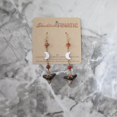 pair of carnelian shark tooth earrings with shell moons, wrapped in bronze wire suspended from 18kt gold plate ear wires
